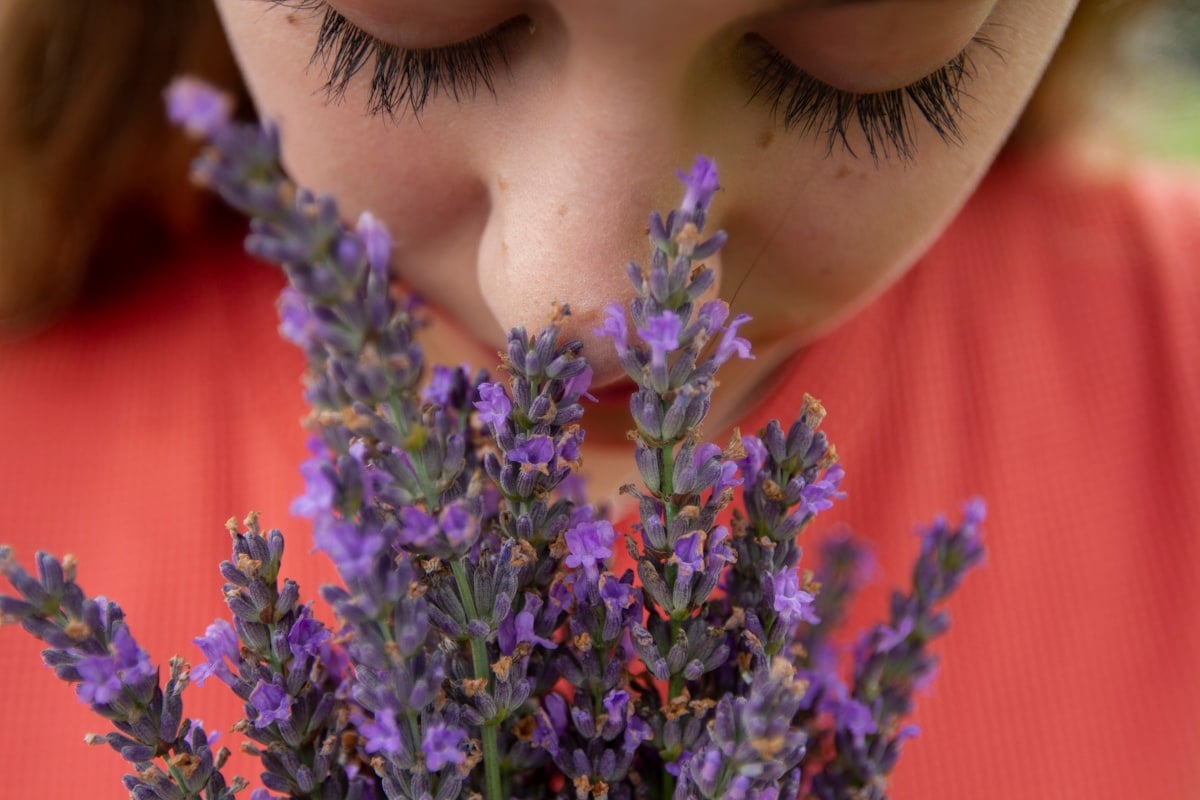 Femme sentant une fleur